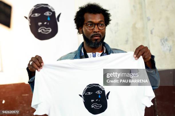 Member of 'Sindicato Popular de Vendedores Ambulantes' Senegalese vendor Mouhamed, shows a t-shirt of their new crowdfunded trademark project 'Top...