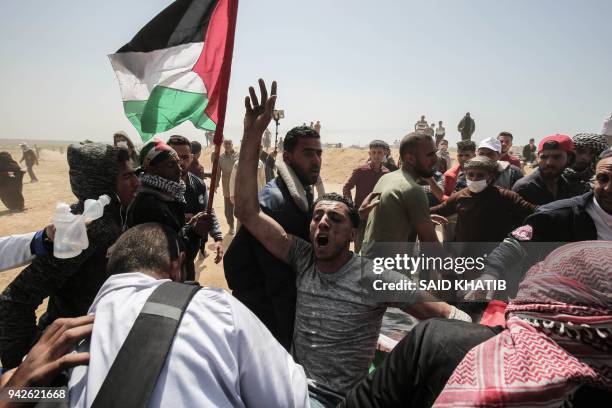 An injured Palestinian protestor is carried by fellow demonstrators during clashes with Israeli security forces following a demonstration calling for...