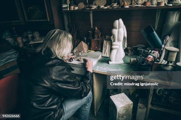 senior using magnifying glass for small art details - glass sculpture stock pictures, royalty-free photos & images
