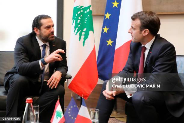 Lebanese Prime Minister Saad Hariri speaks with French President Emmanuel Macron as they attend the international CEDRE conference in Paris on April...