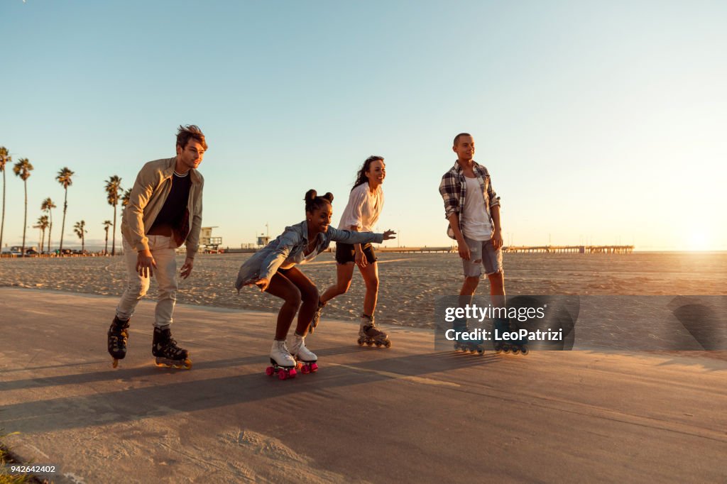 Friends roller skating on the boardwalk in Venice Beach - Santa Monica promenade - Los Angeles, USA