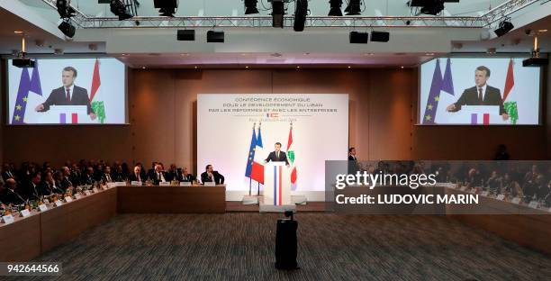 French President Emmanuel Macron delivers a speech, next to Lebanese Prime Minister Saad Hariri , during the international CEDRE conference in Paris...