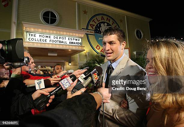 Quarterback Tim Tebow of the University of Florida Gators talks with media representatives as he arrives with friend Kelly Faughnan on the red carpet...
