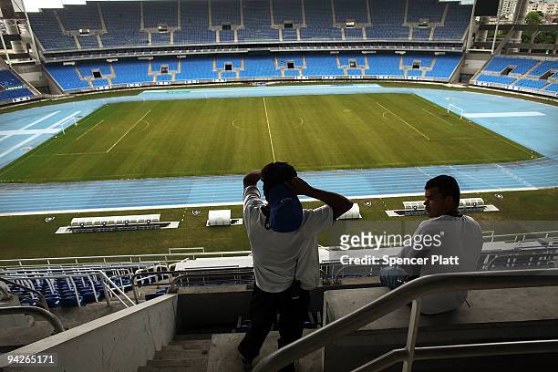 Men cleaning seats look out at the stadium Estadio Olimpico Joao Havelange on December 10, 2009 in Rio de Janeiro, Brazil. The stadium will be used...