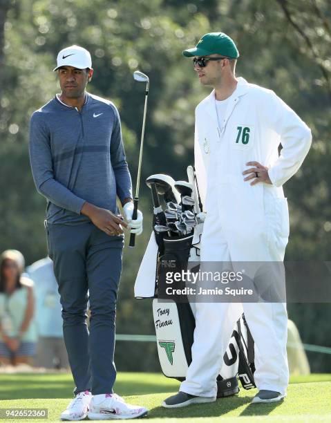 Tony Finau of the United States prepares to play a shot on the first fairway alongside caddie Gregory Bodine during the second round of the 2018...