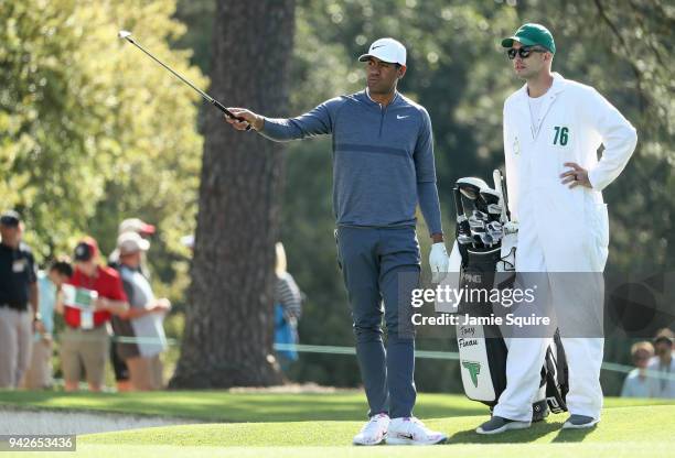 Tony Finau of the United States prepares to play a shot on the first fairway alongside caddie Gregory Bodine during the second round of the 2018...