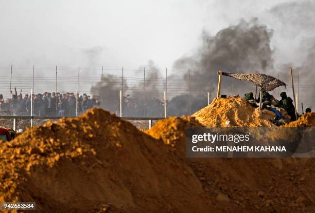 Israeli security forces are deployed near Kibbutz Kerem Shalom on the Israeli border with the southern Gaza Strip as smoke billows from tyres burnt...