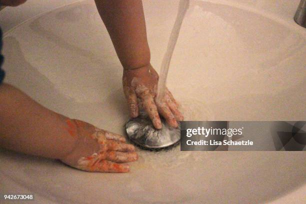 child washes his dirty fingers in the sink - lisa fringer stock pictures, royalty-free photos & images