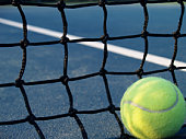 A yellow tennis ball and a black net