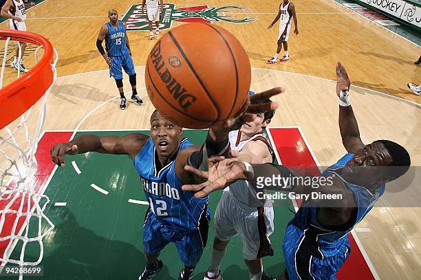 Dwight Howard and Mickael Pietrus of the Orlando Magic go for the rebound during the game against the Milwaukee Bucks on November 28, 2009 at the...