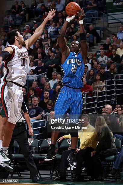 Mickael Pietrus of the Orlando Magic shoots under pressure against Carlos Delfino of the Milwaukee Bucks during the game on November 28, 2009 at the...