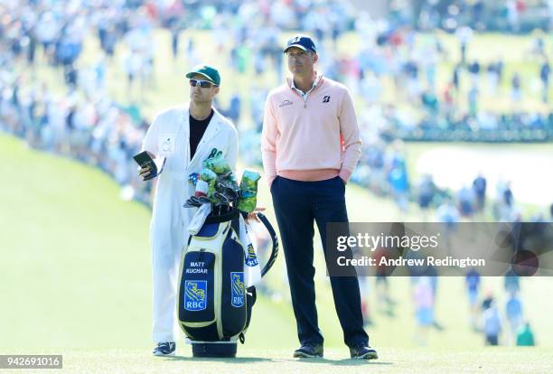Matt Kuchar of the United States and caddie John Wood wait on the first fairway during the second round of the 2018 Masters Tournament at Augusta...