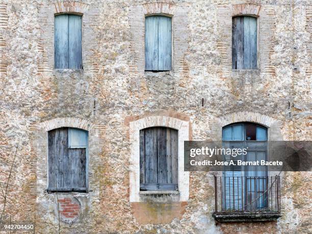 full frame of a ancient  facade of a stone wall with a windows of wooden frame. high resolution photography. - adobe texture stockfoto's en -beelden