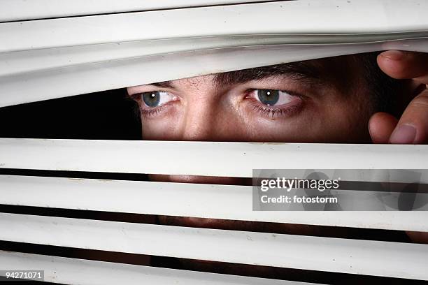 man looking through blinds - vertical blinds stock pictures, royalty-free photos & images