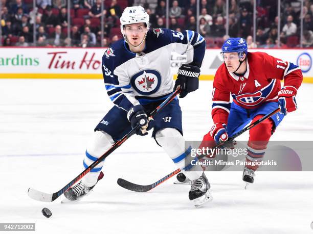 Jack Roslovic of the Winnipeg Jets skates the puck against Brendan Gallagher of the Montreal Canadiens during the NHL game at the Bell Centre on...