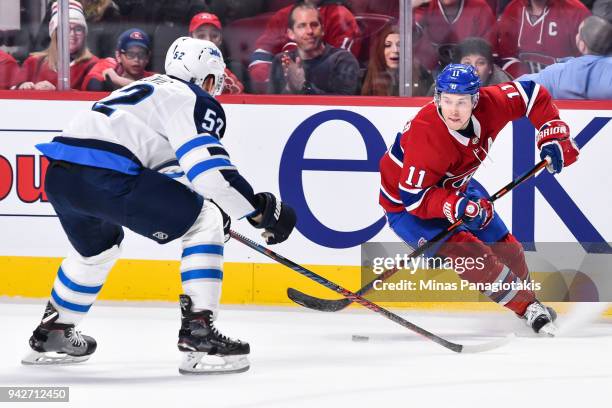 Brendan Gallagher of the Montreal Canadiens skates the puck against Jack Roslovic of the Winnipeg Jets during the NHL game at the Bell Centre on...