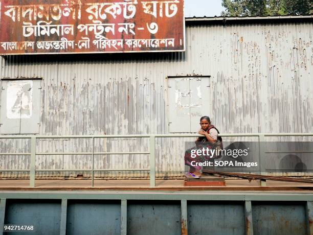 Woman in one of "ghats", metal piers on the river Ganga in Dhaka. Bangladesh is a country on water. With huge portion of its territory in the river...