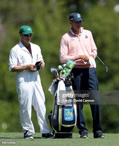 Matt Kuchar of the United States and caddie John Wood wait on the fifth hole during the second round of the 2018 Masters Tournament at Augusta...