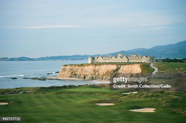 Ritz Carlton Half Moon Bay luxury hotel perched on sea cliffs with Half Moon Bay Golf Links golf course in foreground, Half Moon Bay, California,...