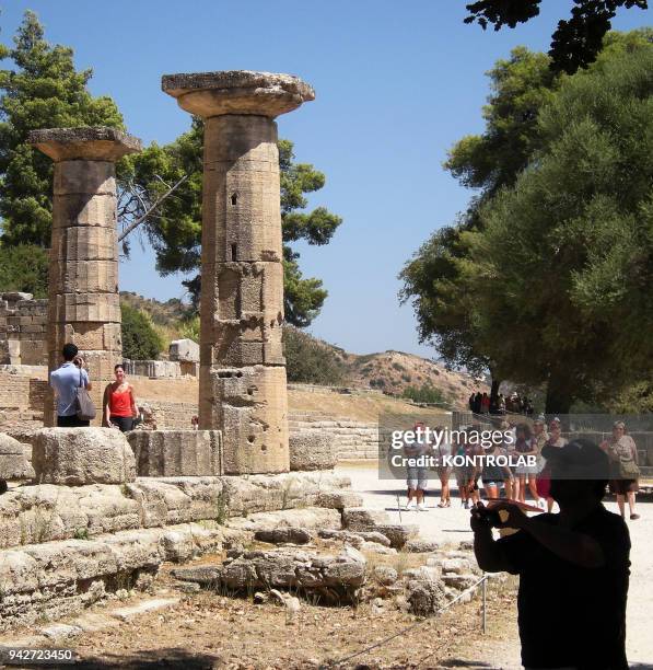 Tourists visit, Zeus temple into the archeological area where are the ruins of Olympia, the ancient Greek town where took place the Olympics.