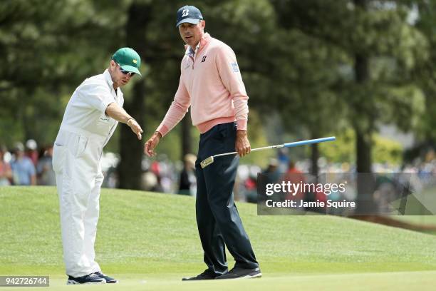 Matt Kuchar of the United States talks with caddie John Wood on the eighth hole during the second round of the 2018 Masters Tournament at Augusta...