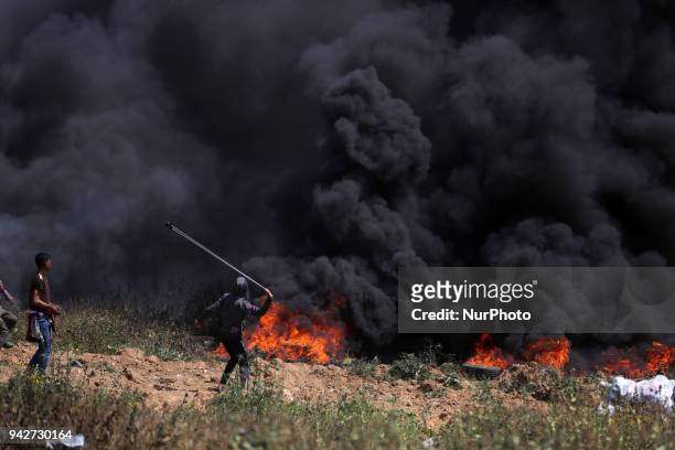 Palestinian protestors gesture during clashes with Israeli security forces on the Gaza-Israel border following a protest calling for the right to...