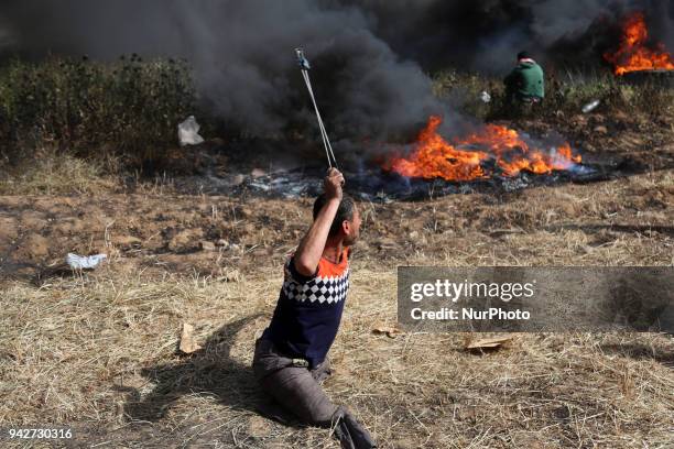 Disabled Palestinian protester hurls stones at Israeli troops during a protest at the Gaza Strip's border with Israel, Friday, April 6, 2018.