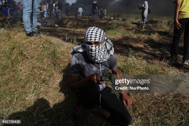 Palestinian protestors gesture during clashes with Israeli security forces on the Gaza-Israel border following a protest calling for the right to...