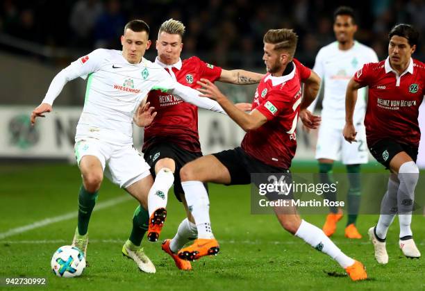 Felix Klaus and Niclas Fuellkrug of Hannover and Maximilian Eggestein of Bremen battle for the ball during the Bundesliga match between Hannover 96...