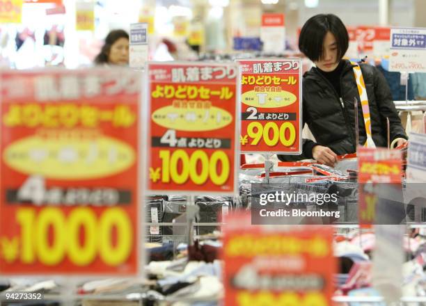 Woman shops for clothes at Seven & I Holdings Co.'s Ito-Yokado supermarket in Tokyo, Japan, on Friday, Dec. 11, 2009. Seven & I Holdings Co., owner...