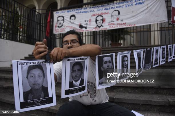 Member of human rights' organization "Hijos" hangs portraits of missing persons within Guatemalan internal armed conflict during a protest at Justice...
