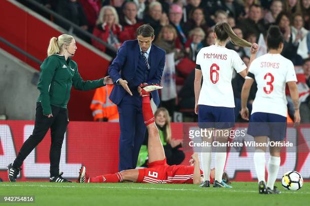 England manager Phil Neville expresses disbelief as he is asked to stop stretching out the leg of Kayleigh Green of Wales by a FIFA official during...