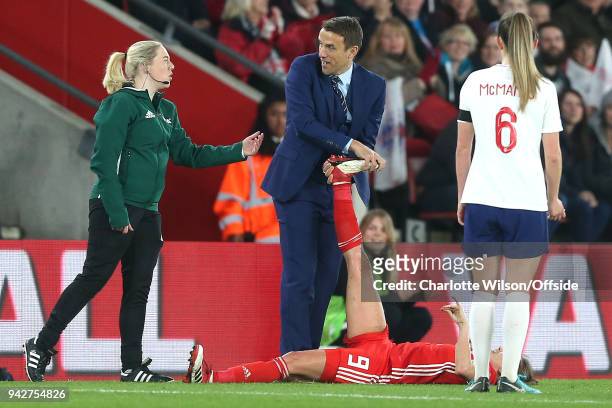 England manager Phil Neville expresses disbelief as he is asked to stop stretching out the leg of Kayleigh Green of Wales by a FIFA official during...