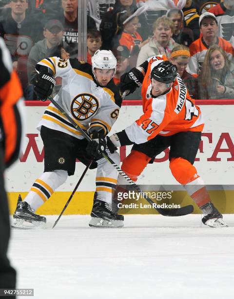 Andrew MacDonald of the Philadelphia Flyers battles against Brad Marchand of the Boston Bruins on April 1, 2018 at the Wells Fargo Center in...