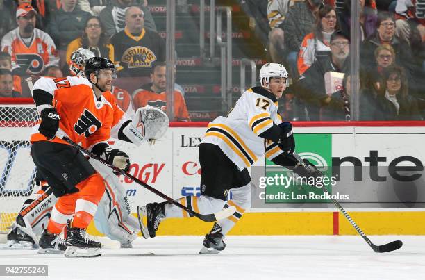 Ryan Donato of the Boston Bruins skate against atop the crease against Andrew MacDonald and Petr Mrazek of the Philadelphia Flyers on April 1, 2018...