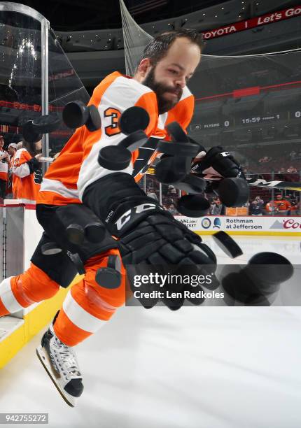 Radko Gudas of the Philadelphia Flyers dumps the pucks onto the ice surface for warm-ups against the Boston Bruins on April 1, 2018 at the Wells...