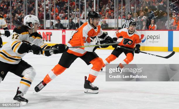 Matt Read and Scott Laughton of the Philadelphia Flyers skate against Torey Krug of the Boston Bruins on April 1, 2018 at the Wells Fargo Center in...