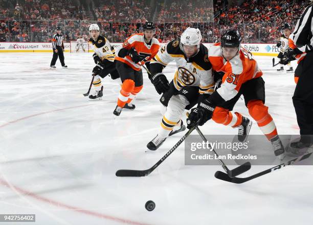 Valtteri Filppula of the Philadelphia Flyers battles for the puck against David Backes of the Boston Bruins with Brandon Manning and Danton Heinen on...