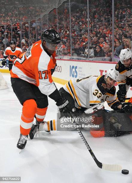 Wayne Simmonds of the Philadelphia Flyers battles for the puck in the corner against Zdeno Chara and Adam McQuaid of the Boston Bruins on April 1,...