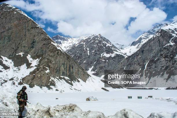 Indian army trooper stands guard at the snow-cleared Srinagar-Leh highway in Zojila, 108 KM far from Srinagar, the summer capital of Indian...