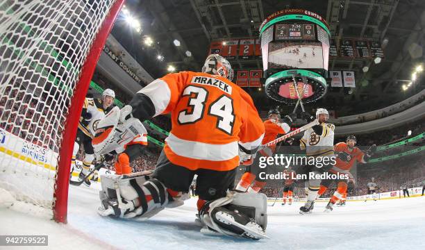 Petr Mrazek, Patrick Nolan and Andrew MacDonald of the Philadelphia Flyers defend their goal against Ryan Donato and David Krejci of the Boston...