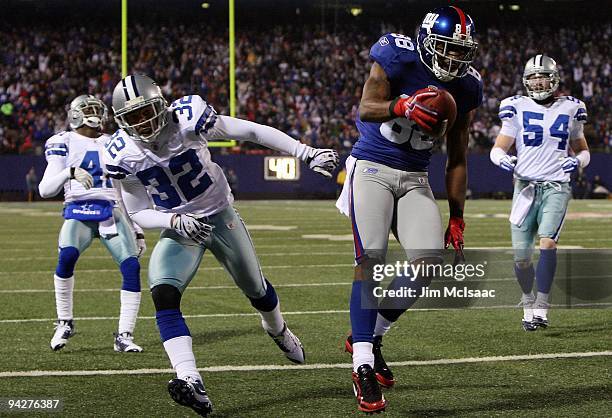 Hakeem Nicks of the New York Giants scores on a 21-yard touchdown reception in the second quarter against Terence Newman, Bobby Carpenter and Orlando...