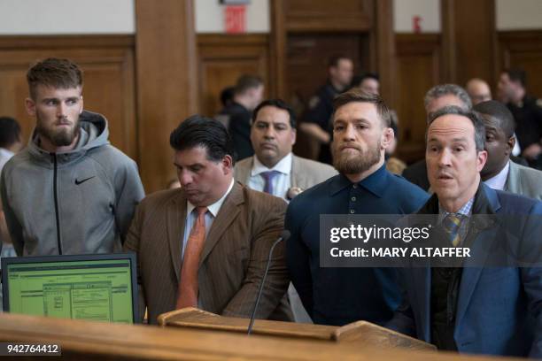 Irish Mixed Martial Arts fighter Conor McGregor looks on next to his lawyer Jim Walden and John Arlia during his arraignment at the Kings County...