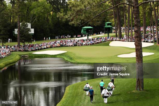 Rory McIlroy of Northern Ireland, Jon Rahm of Spain and Adam Scott of Australia walk to the 16th green during the second round of the 2018 Masters...