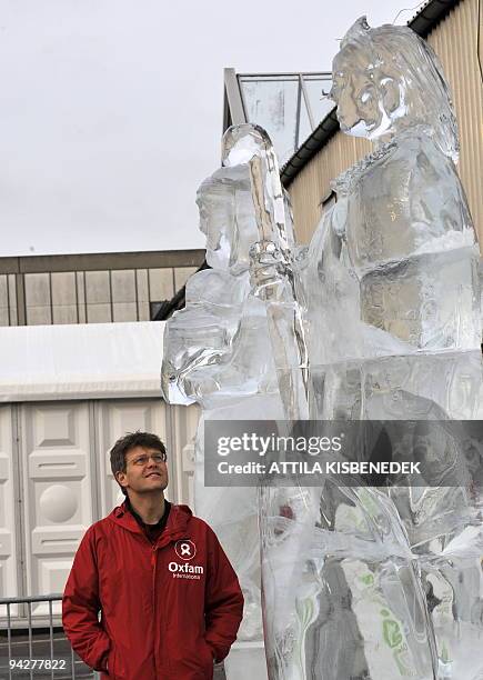 An enviromental activist of the UN Climate Change Conference looks at the three-meter-high ice sculptures at the Bella center in Copenhagen on...