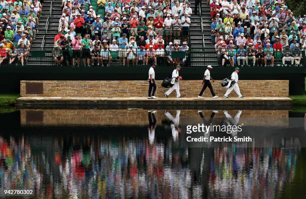 Marc Leishman of Australia and Tiger Woods of the United States cross the Sarazen Bridge on the 16th hole during the second round of the 2018 Masters...