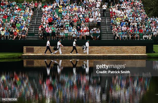 Marc Leishman of Australia and Tiger Woods of the United States cross the Sarazen Bridge on the 16th hole during the second round of the 2018 Masters...