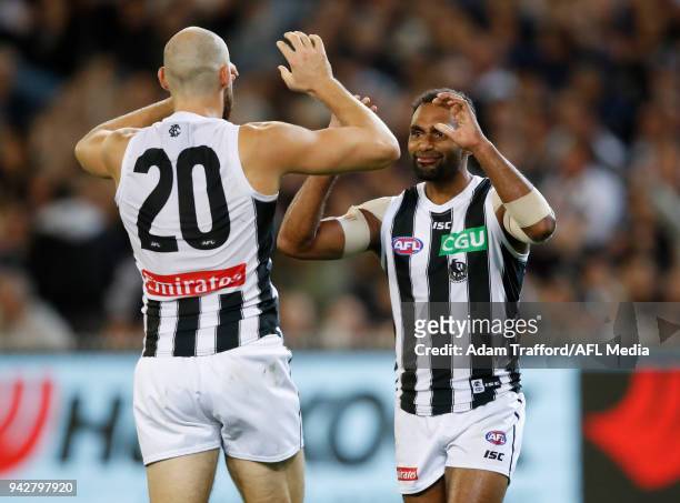 Travis Varcoe of the Magpies congratulates Ben Reid of the Magpies on a goal during the 2018 AFL round 03 match between the Carlton Blues and the...