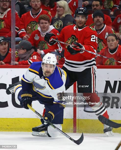 Patrik Berglund of the St. Louis Blues hits the ice after passing in front of Andreas Martinsen of the Chicago Blackhawks at the United Center on...