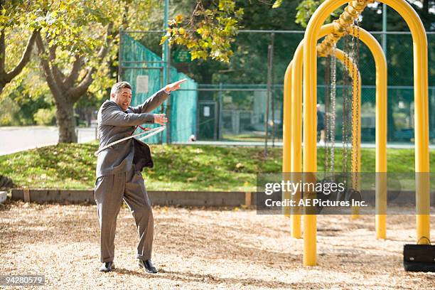 businessman hula hoops on playground - plastic hoop stock pictures, royalty-free photos & images